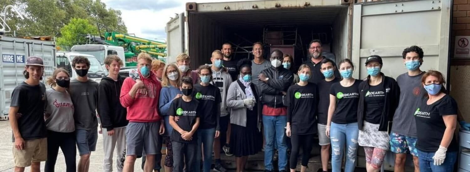 Med Earth - group of volunteers standing in front of a 40 foot container.